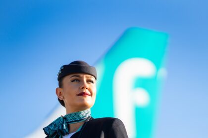 Woman flight attendant stood in front of an airplane