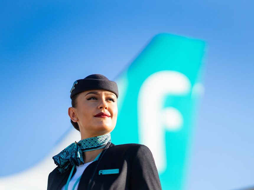 Woman flight attendant stood in front of an airplane