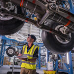 Engineer inspects Airbus landing gear system at Filton site. Image illustrating Airbus UK strike 2025 pay dispute.