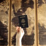 Hand holding a United States passport against a vintage world map background, symbolising global mobility, aviation trends, and shifting passport rankings.