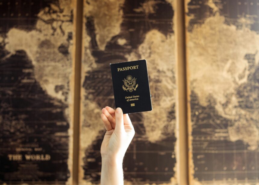 Hand holding a United States passport against a vintage world map background, symbolising global mobility, aviation trends, and shifting passport rankings.