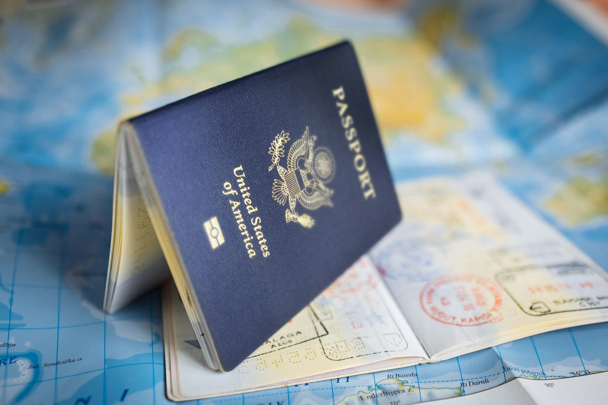 US passport on top of a stamped passport, illustrating passport rankings, US passport decline, aviation trends, and travel diplomacy.