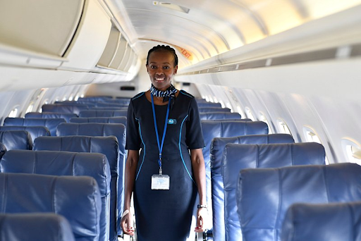 A flight attendant stood in an empty aircraft aisle