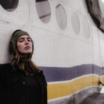 A woman standing next to a plane