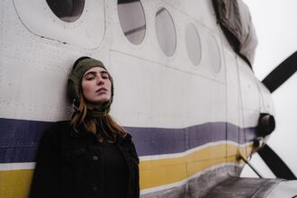 A woman standing next to a plane