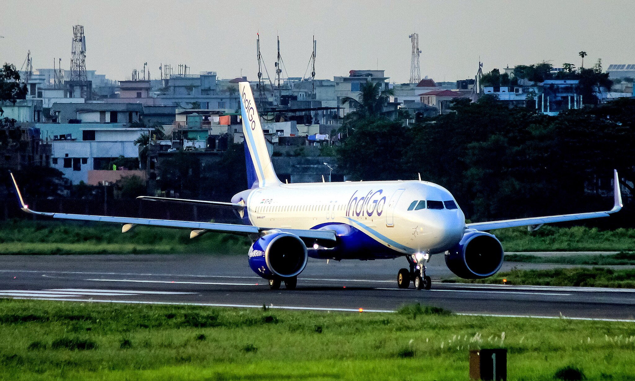 An IndiGo aircraft landing on the tarmac.