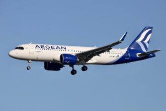 A blue and white Airbus A320 NEO flying for Aegean airlines.