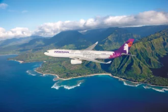 A Hawaiian Airlines Airbus A330 flying over Kaua‘i’s lush coastline. The aircraft is part of Hawaiian’s sustainable aviation fuel flights program, supporting SAF-powered operations on the Osaka–Honolulu route.