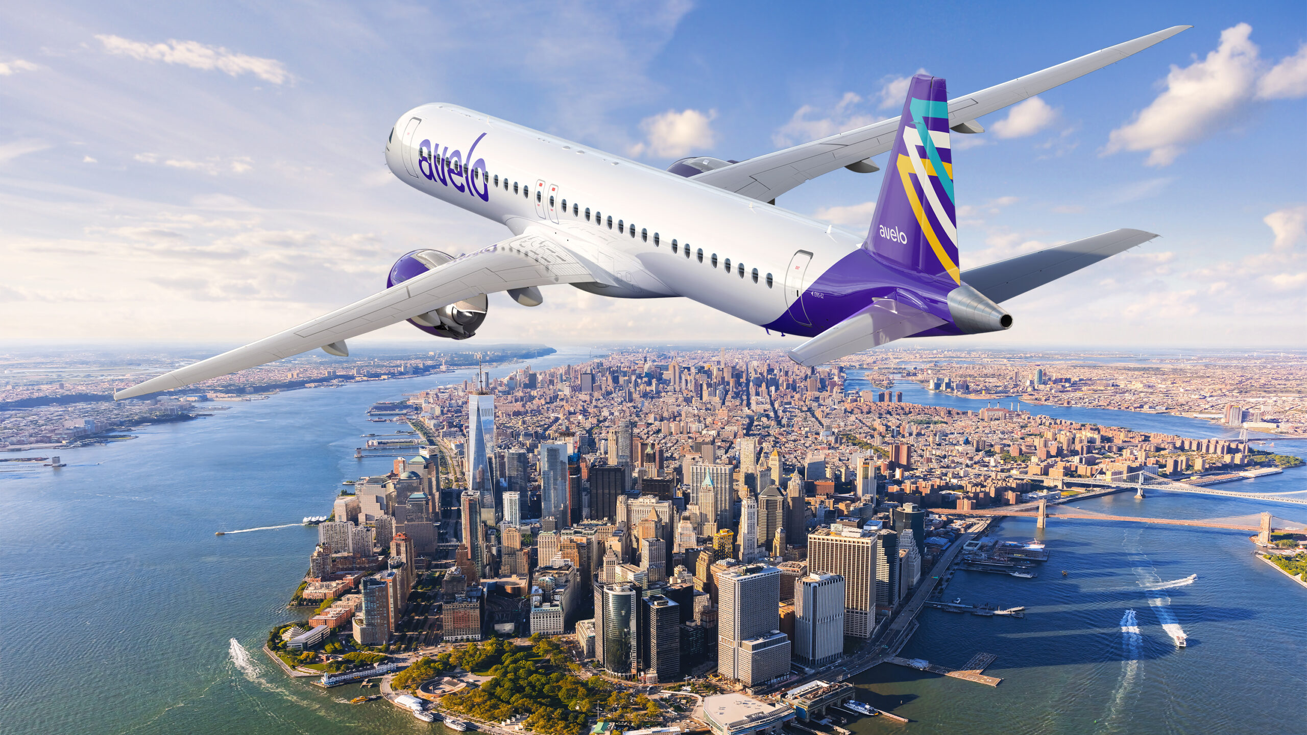 An Avelo Airlines airplane is flying over New York City, with a clear view of the Manhattan skyline and the surrounding rivers. The aircraft is white with purple accents and the Avelo logo on its body and tail.