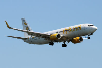 A yellow and white Flybondi aircraft coming in for landing.