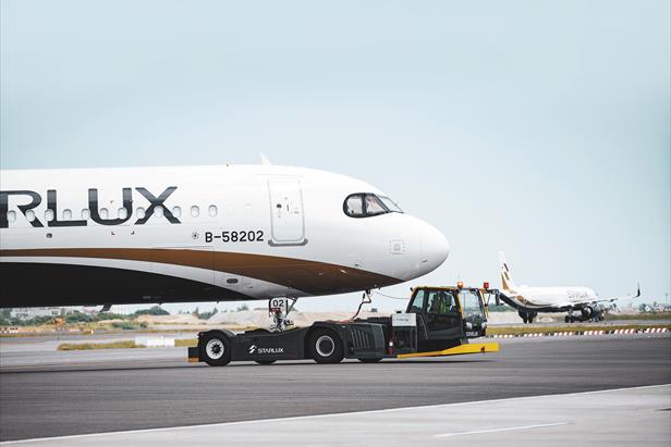 A STARLUX Airlines aircraft with registration B-58202 is towed by a ground vehicle on the runway, with another plane visible in the background.