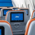 JetBlue seatback screens showing the airline’s logo, highlighting JetBlue free Wi-Fi and in-flight connectivity services.