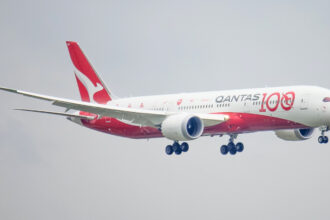 A Qantas plane coming in for landing which is decorated in a special livery for the airline's 100th anniversary.