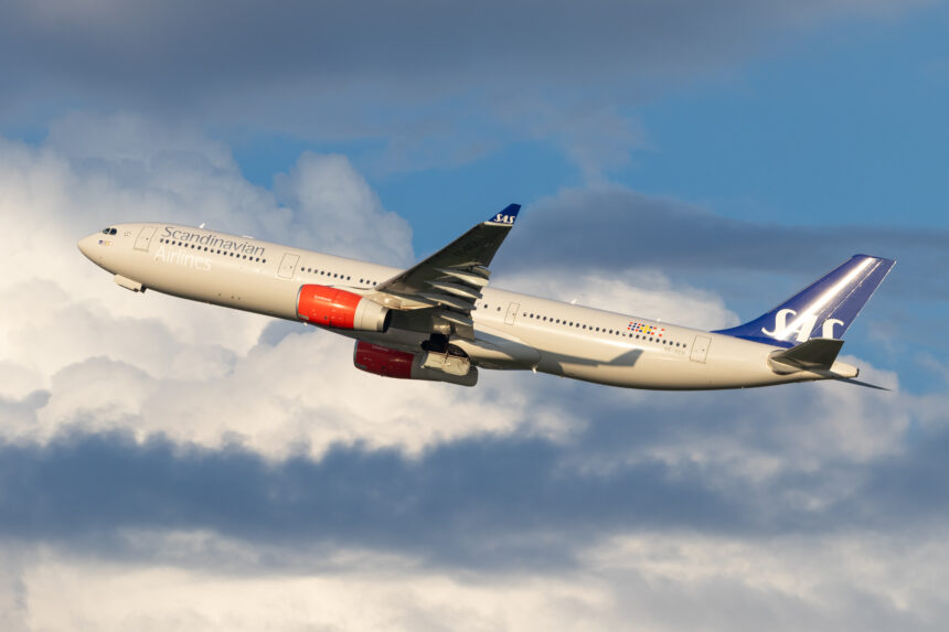 An SAS Scandinavian Airbus plane taking off from Washington airport and soaring through a cloudy blue sky.
