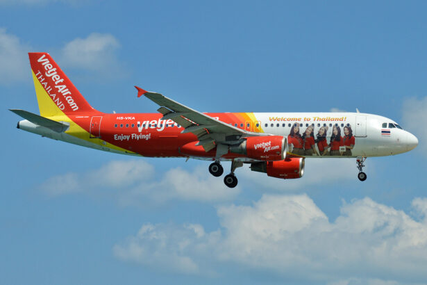 A VietJet Thailand aircraft in the sky with pictures of flight attendants on the plane body.