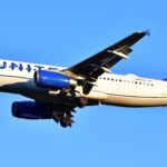 A United airlines plane in the blue sky.