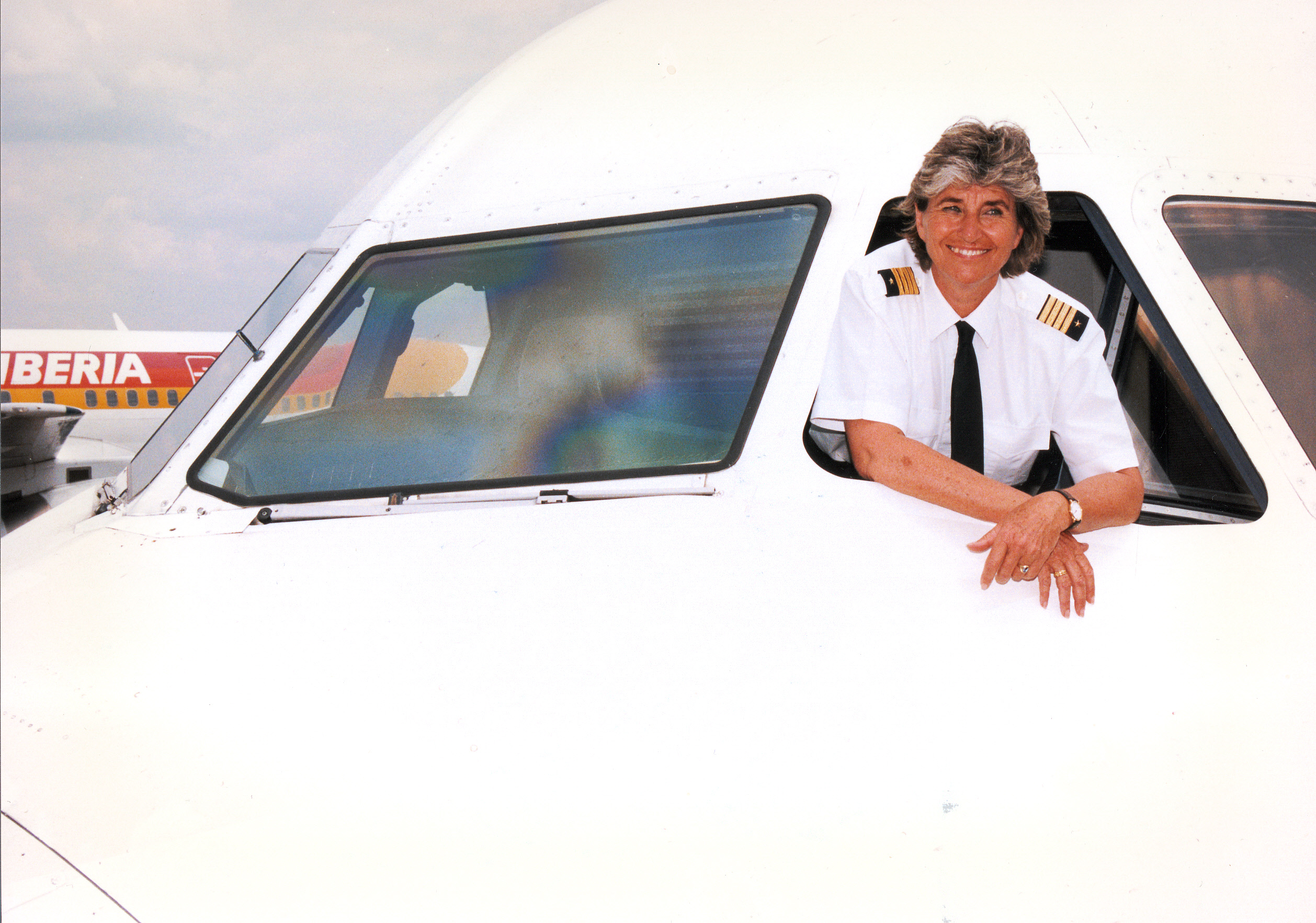 Bettina Kadner leaning out of the cockpit of a plane in a photo from her career (1980s).
