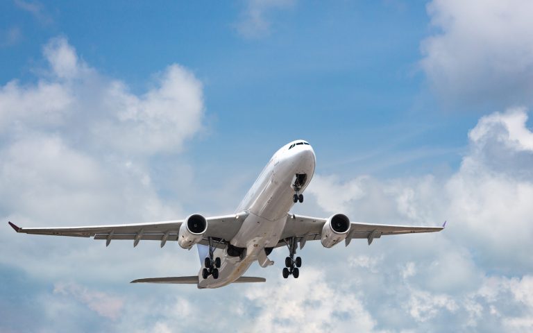 Passenger airplane taking off in bright cloudy sky