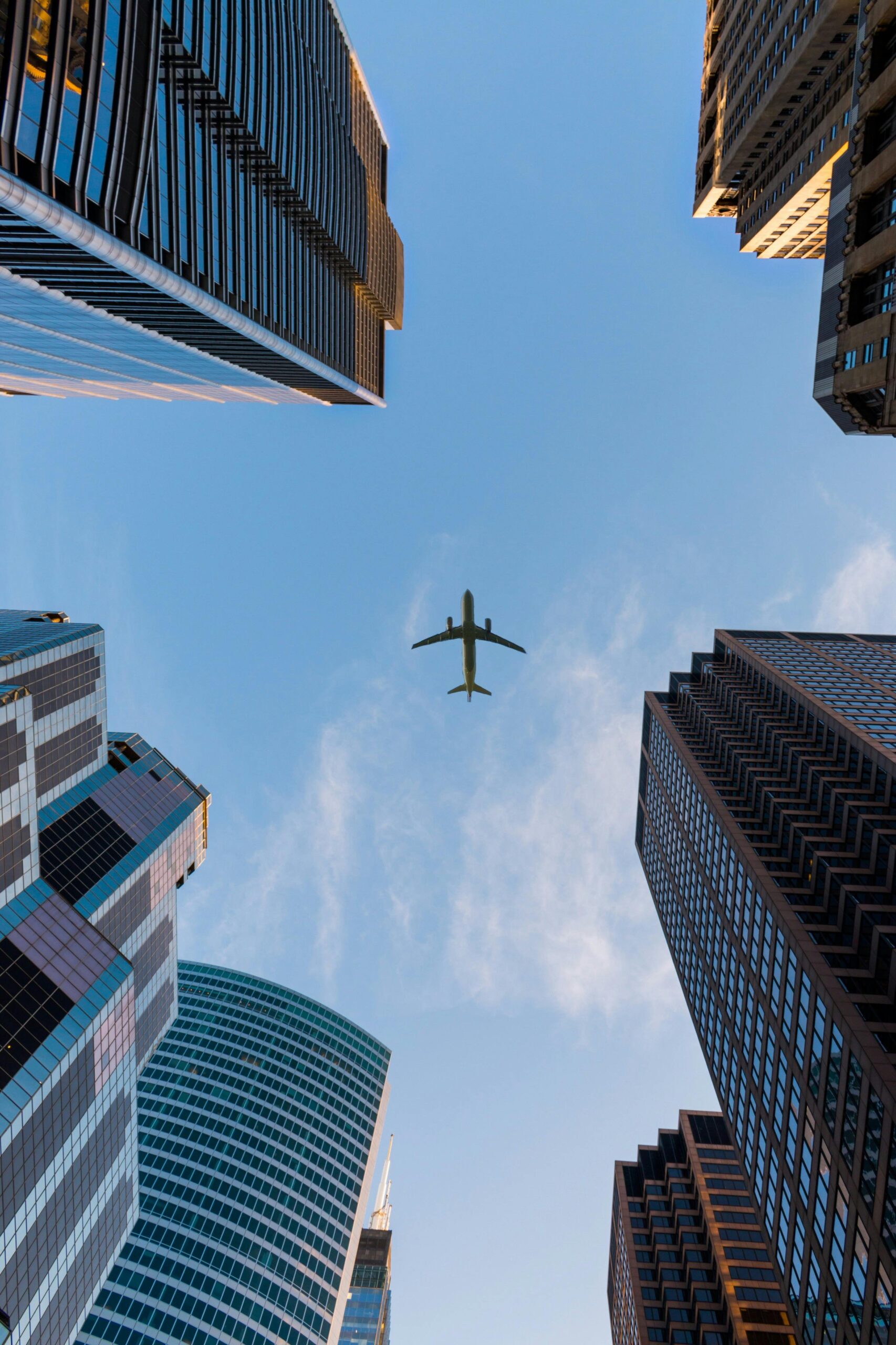 Low Angle Photography of Airplane and high rise buildings