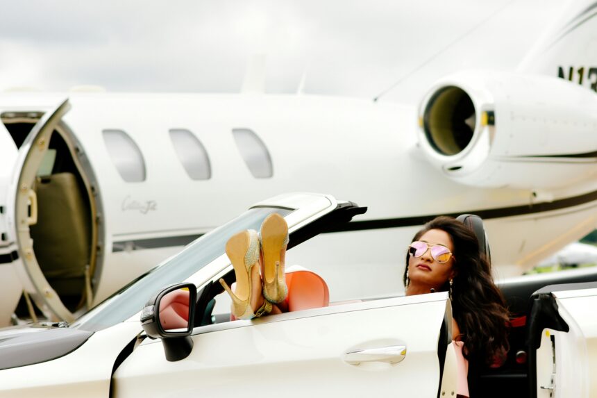 A woman in a sports car in front of a private jet.