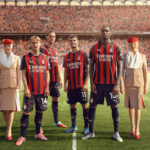 Representatives from AC Milan wearing the sponsored jersey, with two Emirates flight attendants.