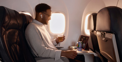 A customer enjoying a Heineken 0.0 drink on Air Canada flight