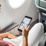 A woman scrolling on social media on a Cathay Pacific flight.