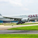 A Qatar Airways cargo plane coming in for landing on the runway.