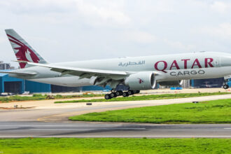 A Qatar Airways cargo plane coming in for landing on the runway.