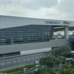 The outside of Delhi Airport terminal 3, with a sign labelling it as Terminal 3 in English and Hindi.