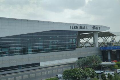 The outside of Delhi Airport terminal 3, with a sign labelling it as Terminal 3 in English and Hindi.