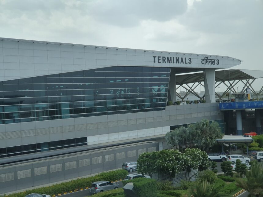 The outside of Delhi Airport terminal 3, with a sign labelling it as Terminal 3 in English and Hindi.