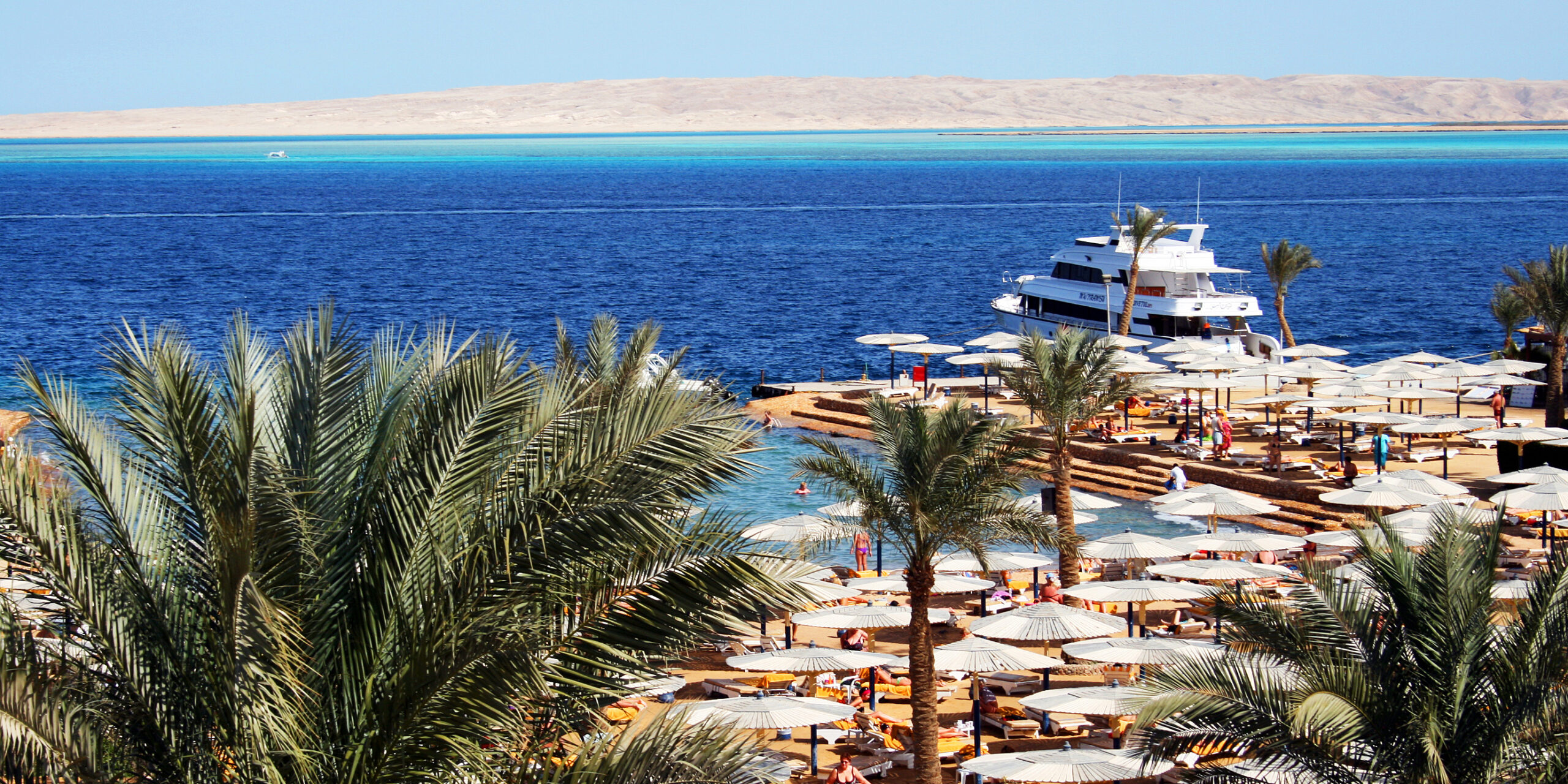 A small marina with boats moored and bright blue water in Hurghada.