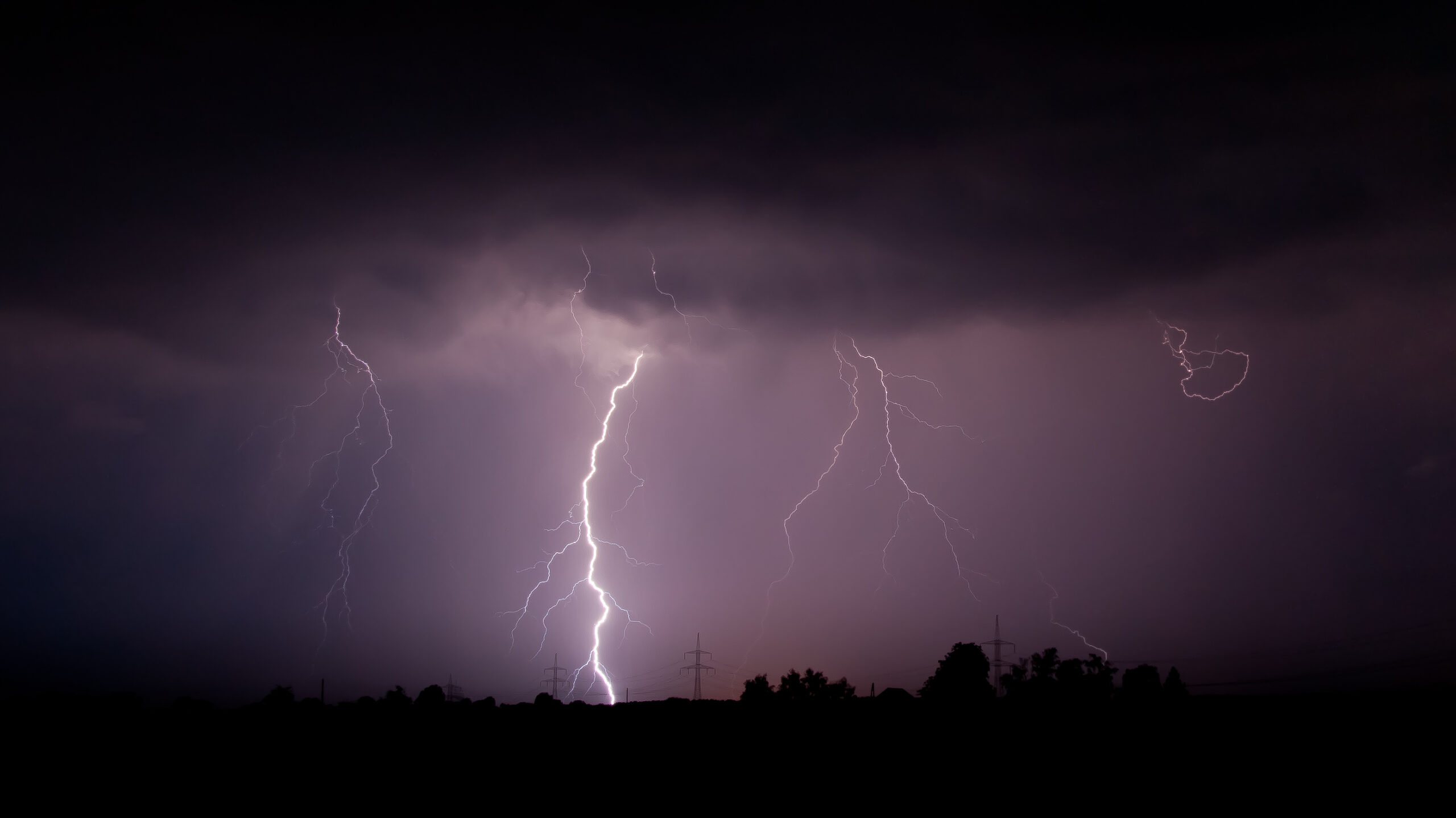 Night purple sky with a massive lightning bolt striking, illustrating lightning safety and dramatic lightning activity.