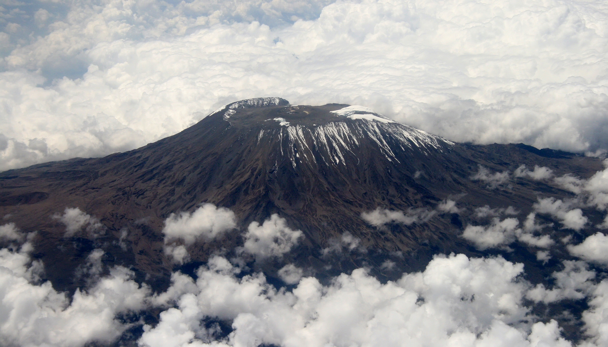 The peak of Mount Kilimanjaro surrounded by thick clouds.