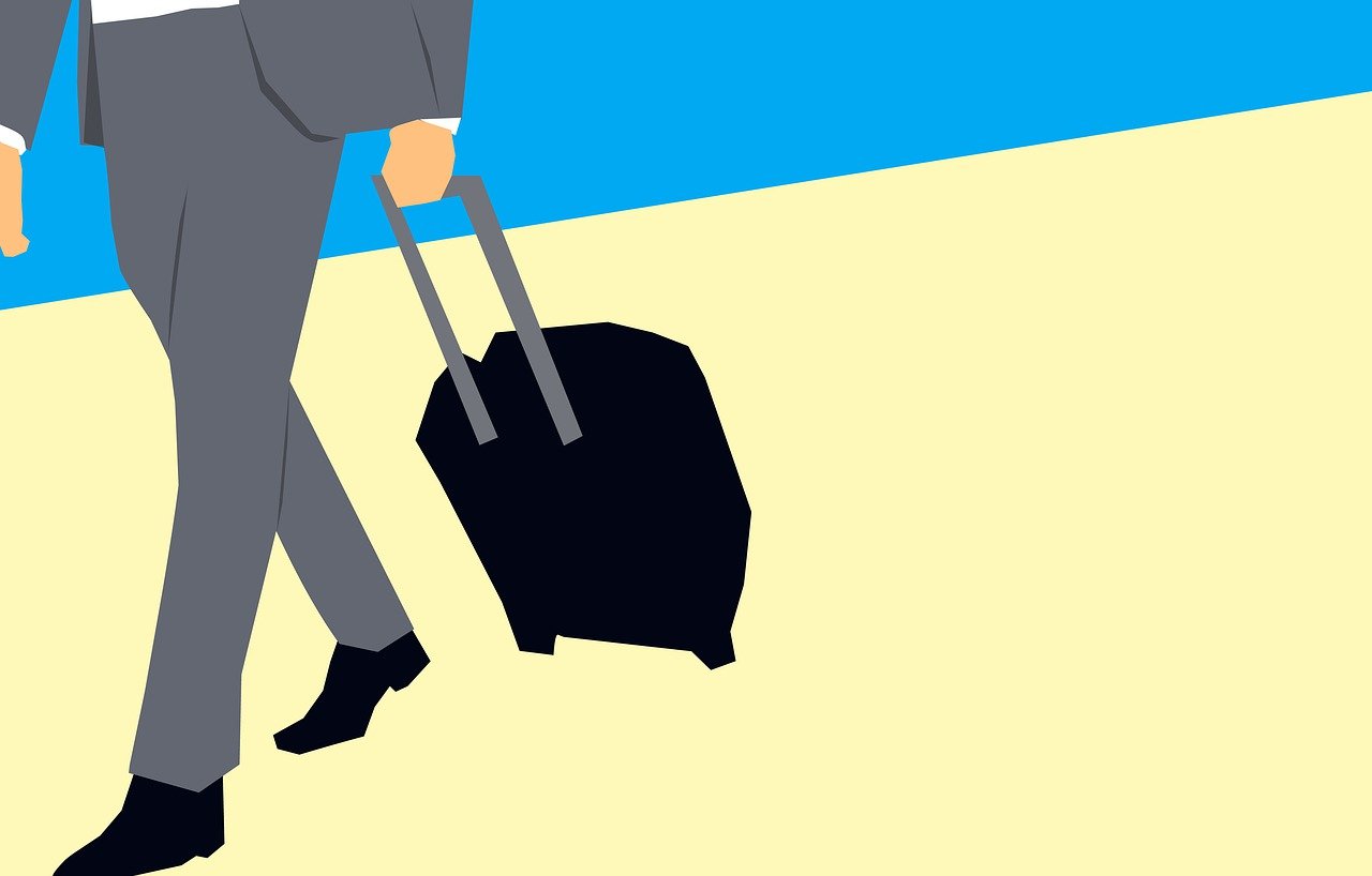 Business traveler in a grey suit walking with a suitcase, symbolising business aviation growth 2025 and the rise of corporate travel worldwide.
