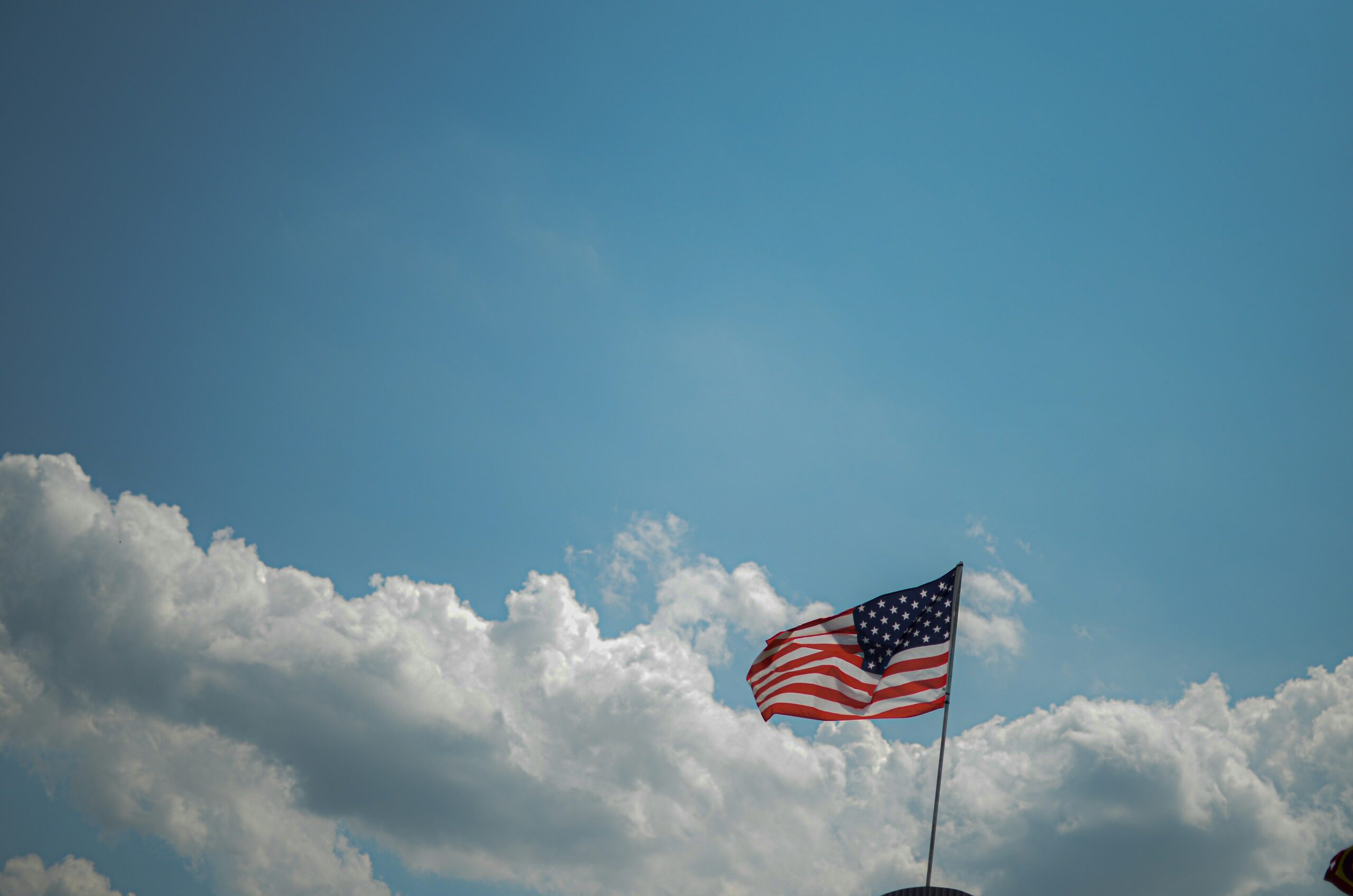 U.S. flag waving in the wind with blue skies 