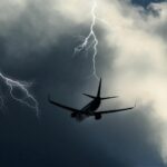Commercial airplane flying through a thunderstorm with multiple lightning strikes, illustrating airplane lightning strike, lightning safety, and aircraft design.