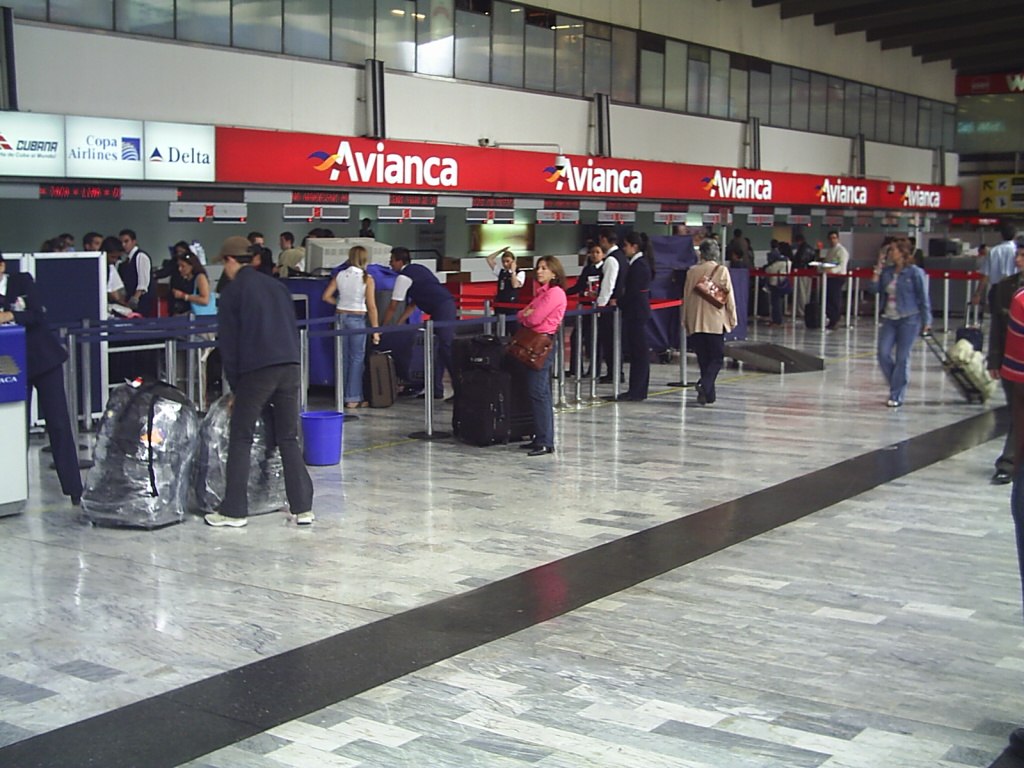 Red and white Avianca check in desks at El Dorado airport, Colombia.