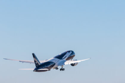 A Lufthansa plane with special livery takes off into a blue sky.