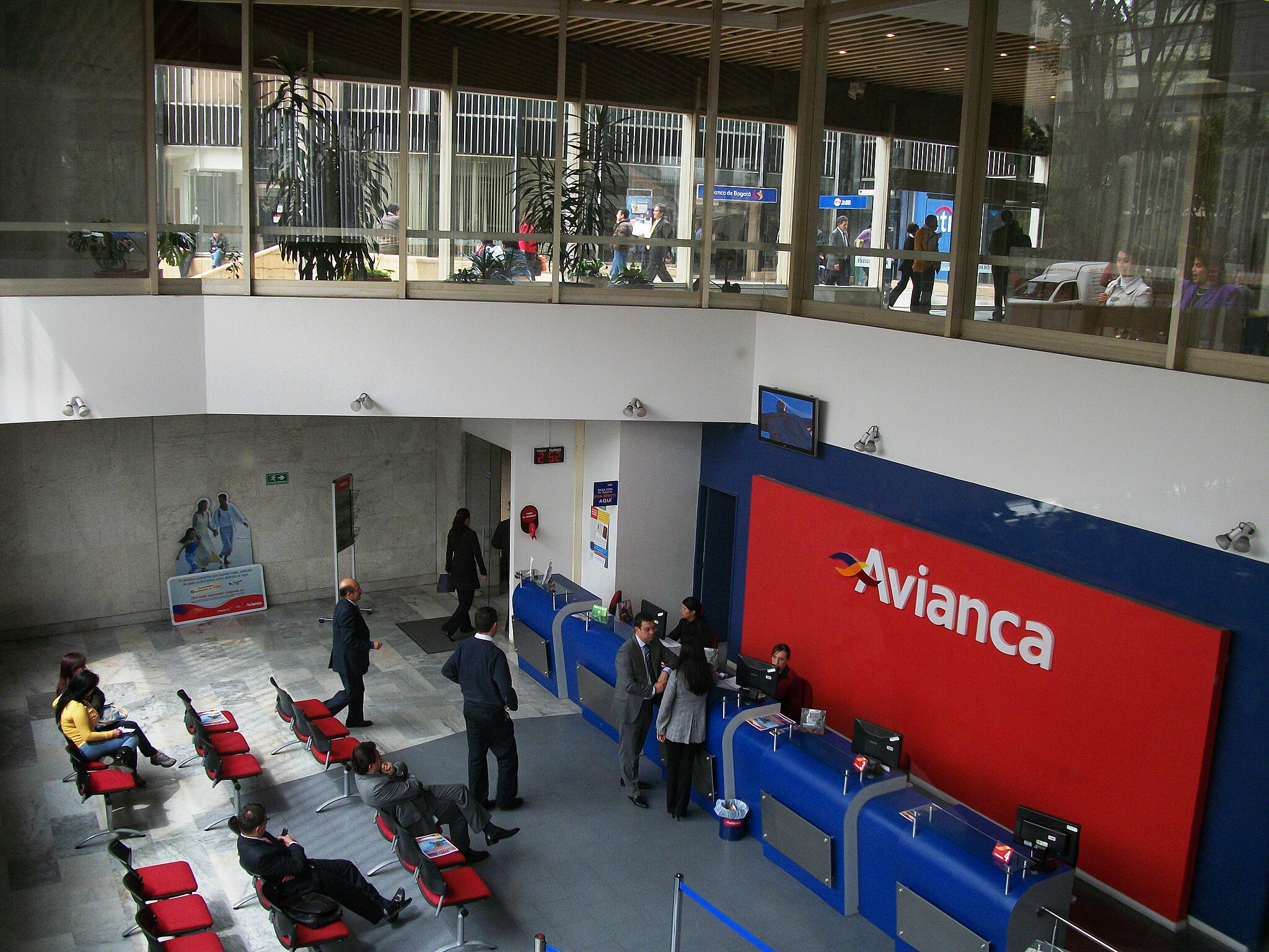 Inside the Avianca headquarters in Bogota, people sit in chairs facing reception desks.