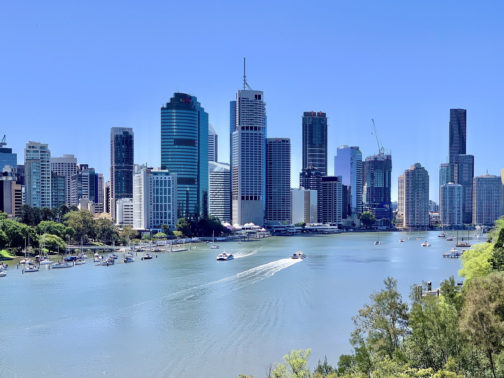 The Brisbane skyline with the Brisbane river in front of some high-rise buildings.