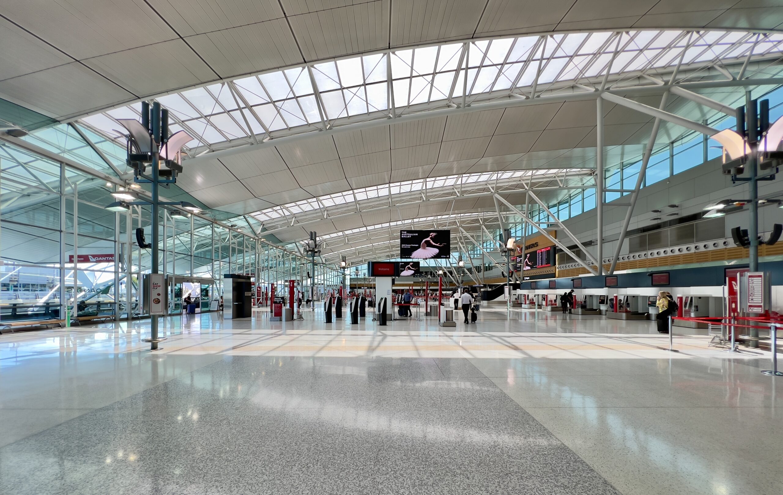 Sydney Airport Terminal 3 with large windows to the outside and check in desks visible.