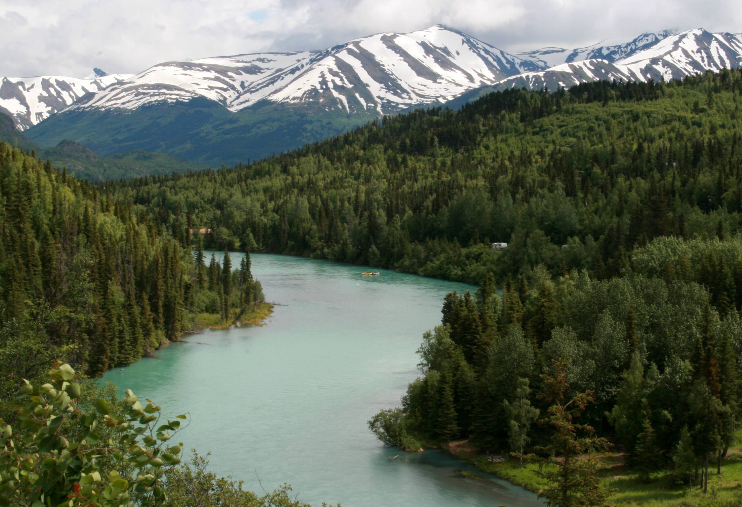 The Kenai River with mountains and forest in the background.