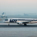 A LOT Polish Airlines aircraft coming in for landing on a snowy runway.