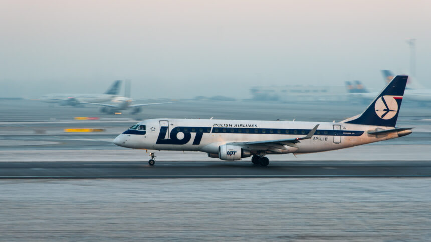 A LOT Polish Airlines aircraft coming in for landing on a snowy runway.