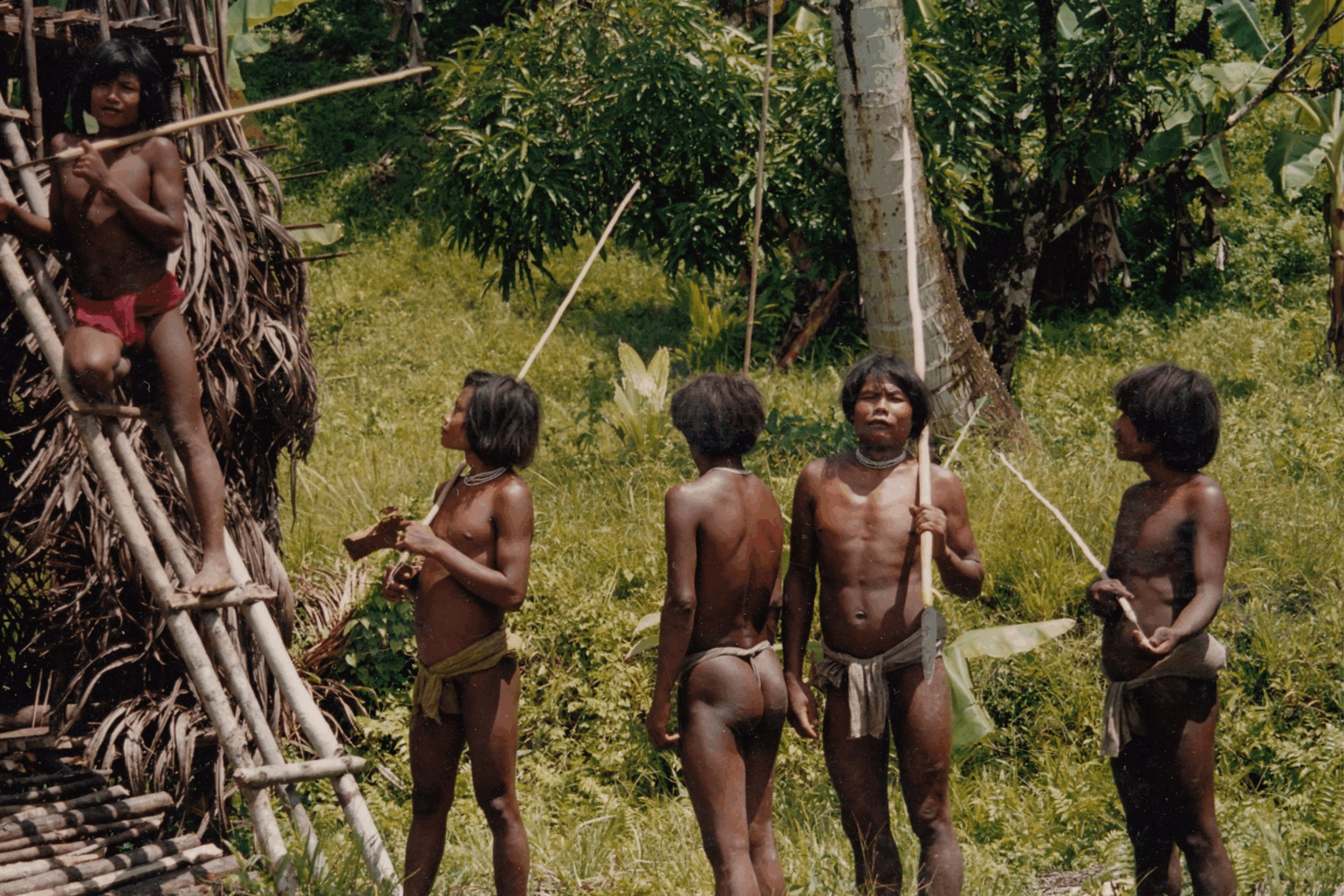 A group of young Shompen men next to their house on Great Nicobar Island.