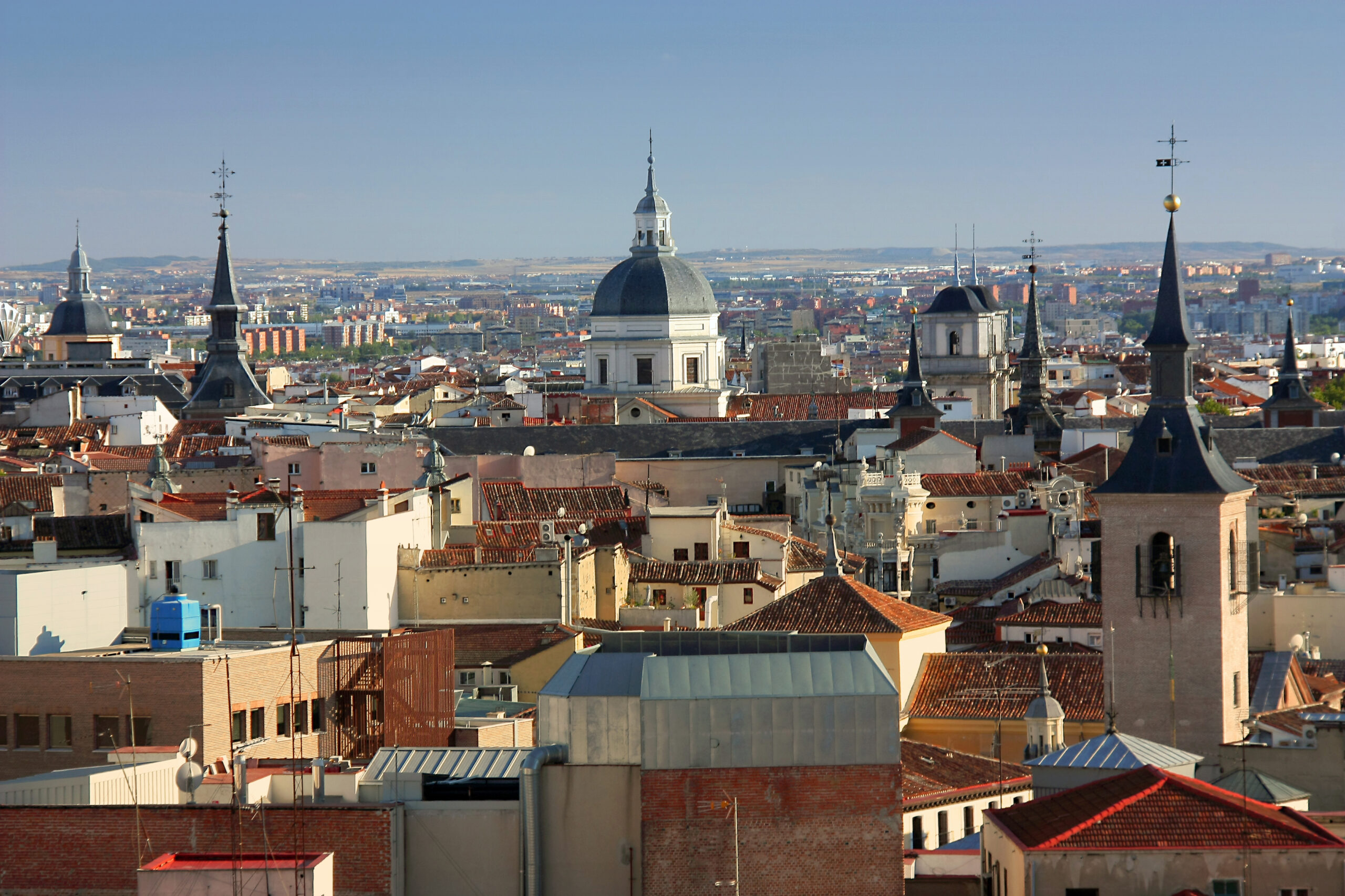 A view of Madrid's skyline with a large church in the centre and a tower on either side of it.