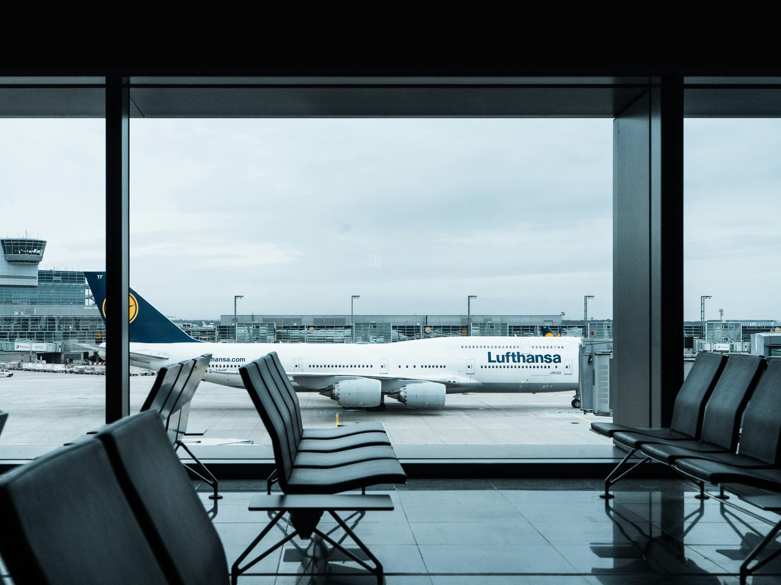 Lufthansa Aircraft seen through the window of a terminal waiting area.