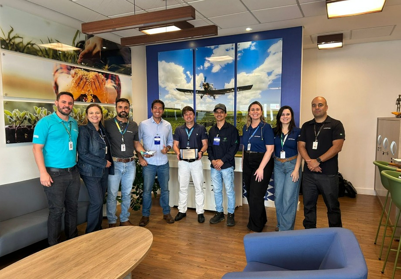 A collection of Embraer staff celebrating the delivery of 1700 Ipanema Cropdusters